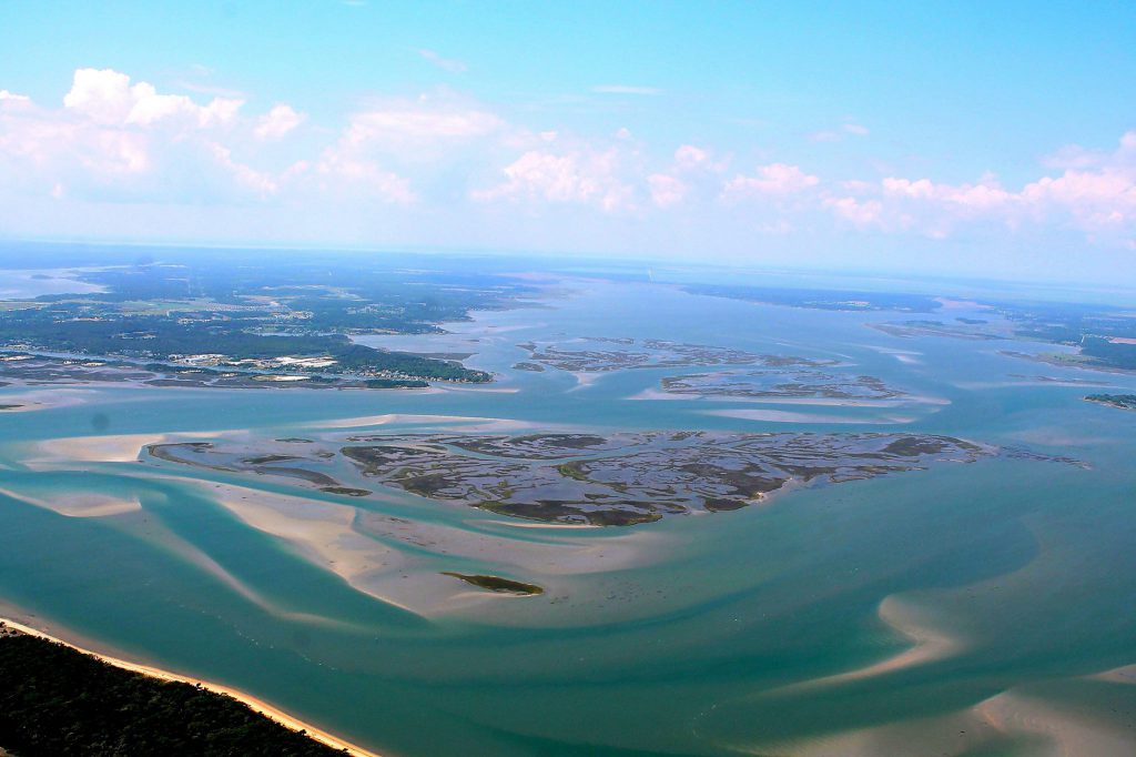 aerial view of barrier islands with a small coastal town in the background.