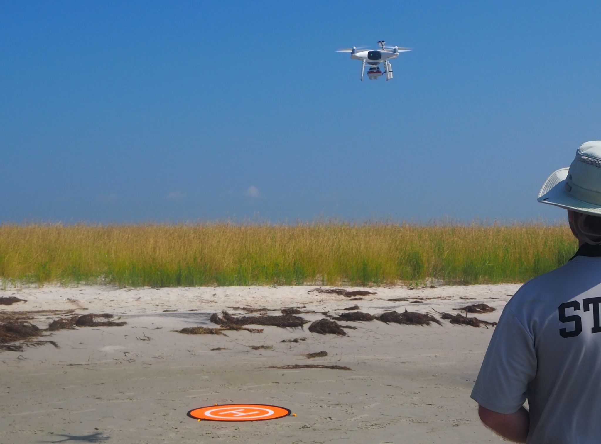 NCCOS researcher tests Unoccupied Aerial System along U.S. East Coast wetland.