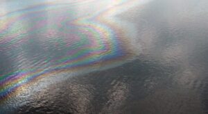 iridescent substance coating the surface of water.