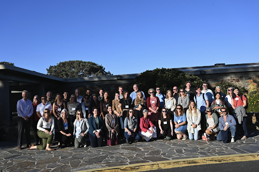 Group of people posing for a photo on a stone sidewalk