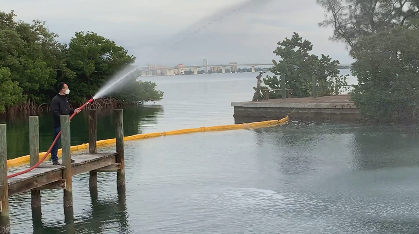 Clay being sprayed onto water in a Florida marina to aggregate and sink harmful algae. Once sunk, the algae die and decay.