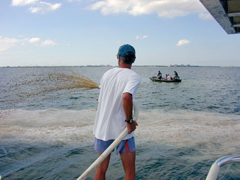  man uses hose to spray clay onto Sarasota Bay

