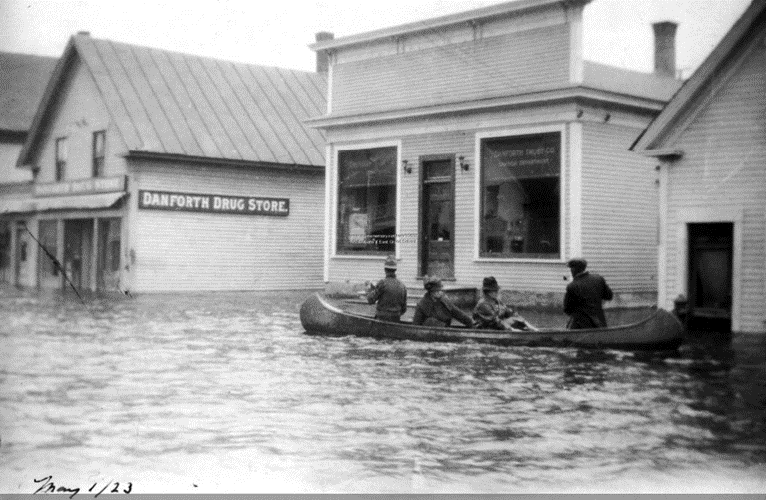 Men canoeing down Central Street in Danforth, Maine after a flood in 1923. 