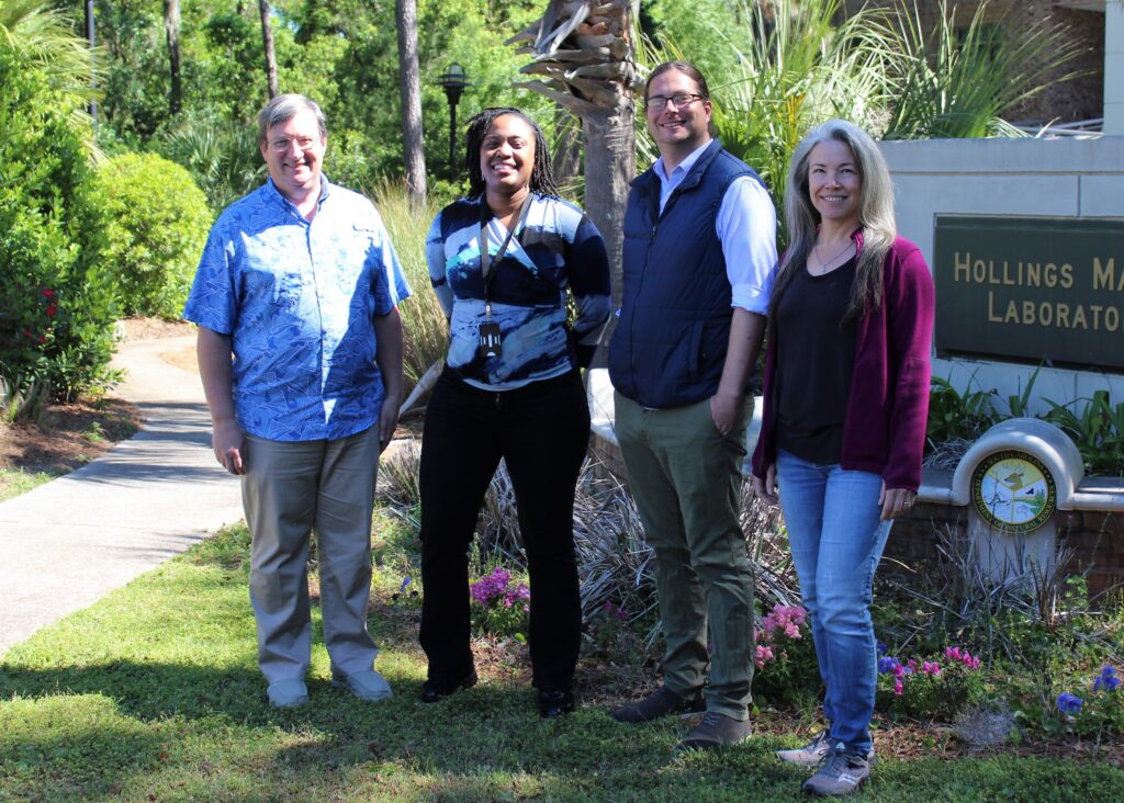 Four people smiling outside