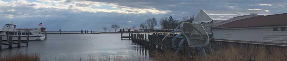 A building on a wharf next to a dock extending into the water.