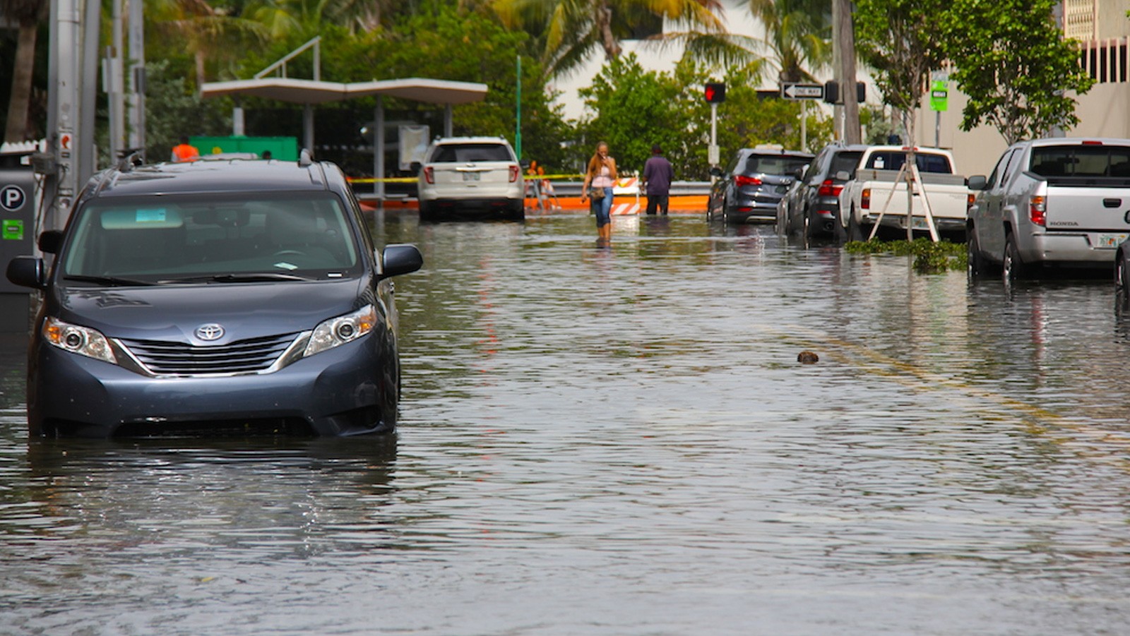 High-tide flooding submerges vehicles on a street in Miami Beach