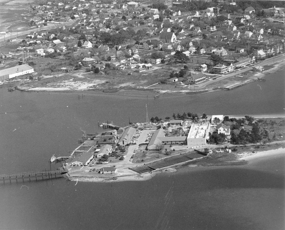 Black and white view of multiple buildings on an island.